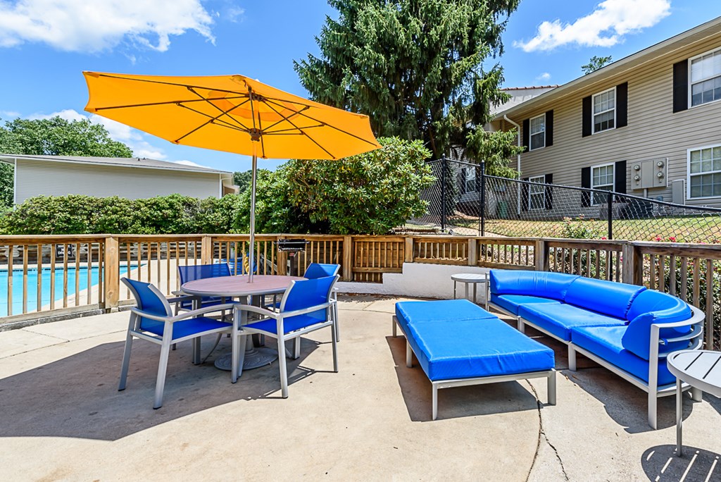 a patio with chairs and tables and an umbrella