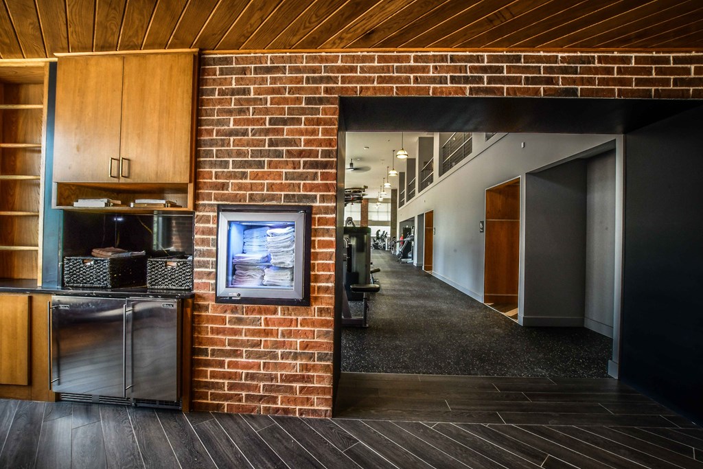 a brick wall in a building with a refrigerator and a microwave
