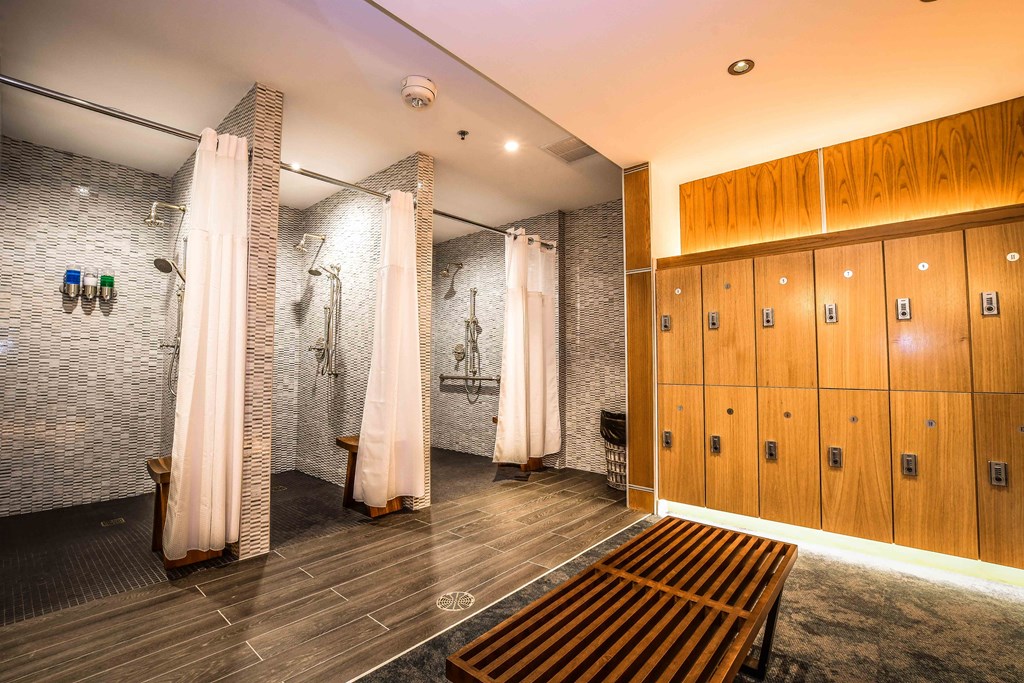 a locker room with lockers and showers and a bench