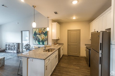 A kitchen with white cabinets and a brown refrigerator.