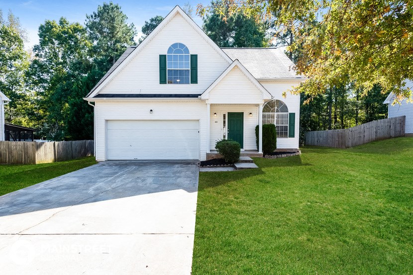 a white house with a white garage door and a lawn