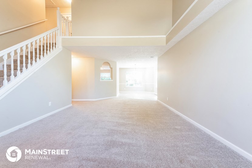 the living room and dining room of an empty house