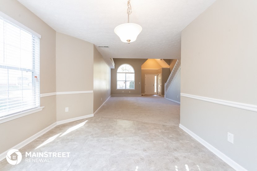 an empty living room and hallway with a large window