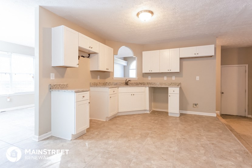 a large kitchen with white cabinets and a counter top