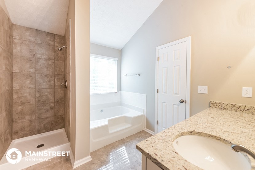 a bathroom with a tub and a sink and a mirror