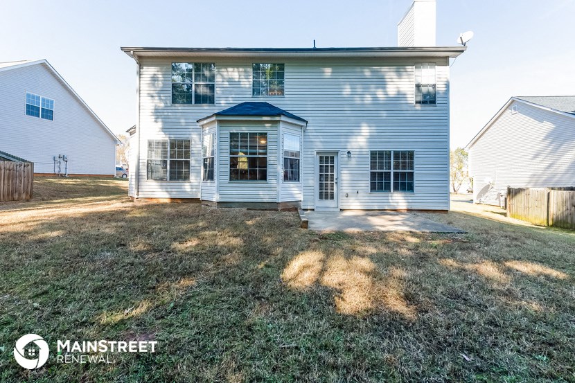 a blue and white house with a yard and a fence