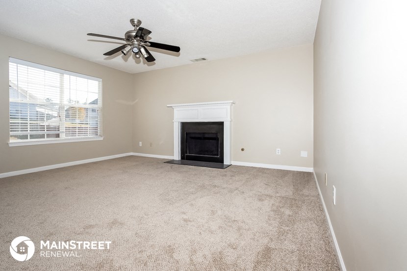 a living room with a fireplace and a ceiling fan