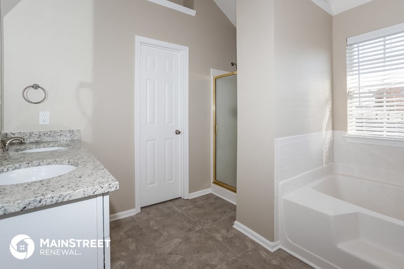 a bathroom with a tub and a sink and a mirror