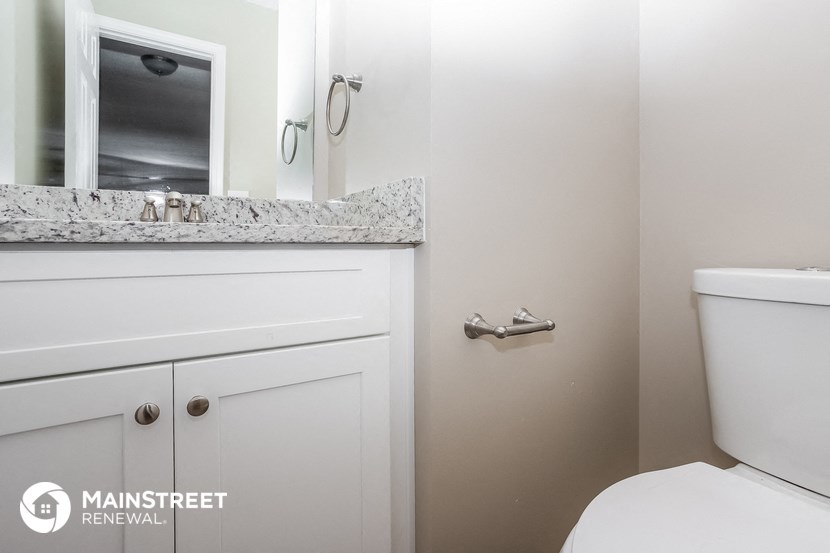 a bathroom with a toilet and a sink and a mirror