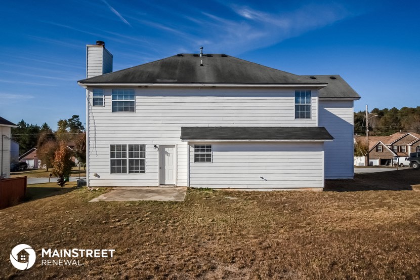 a white house with a gray roof on a field