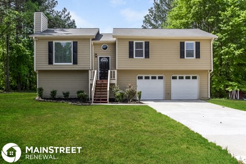 a beige house with a garage and a lawn