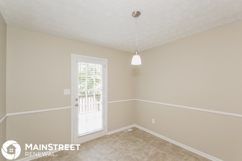 an empty room with a door and a light hanging from the ceiling