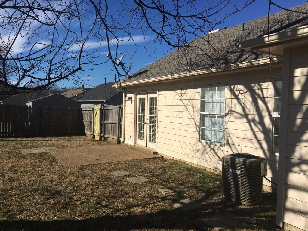 a side view of a house with a yard and a fence
