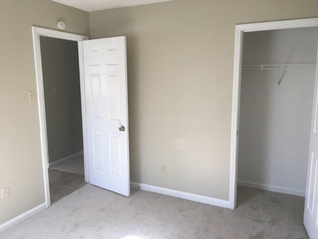 an empty room with a closet and an open door