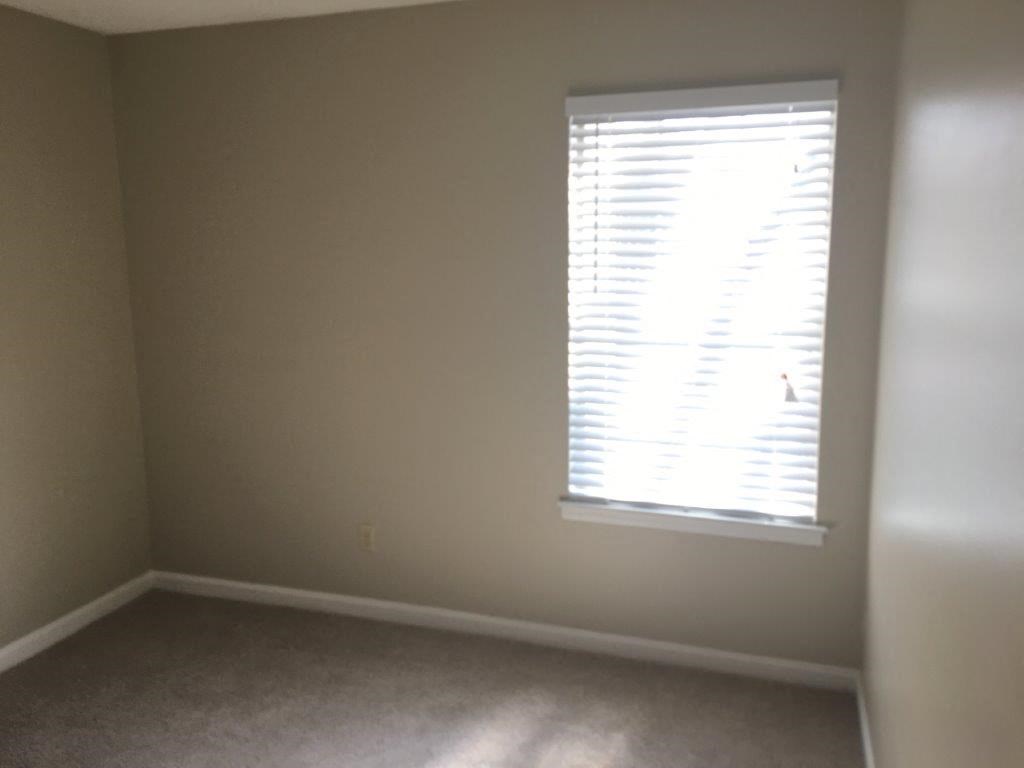 a room with a window and a carpeted floor