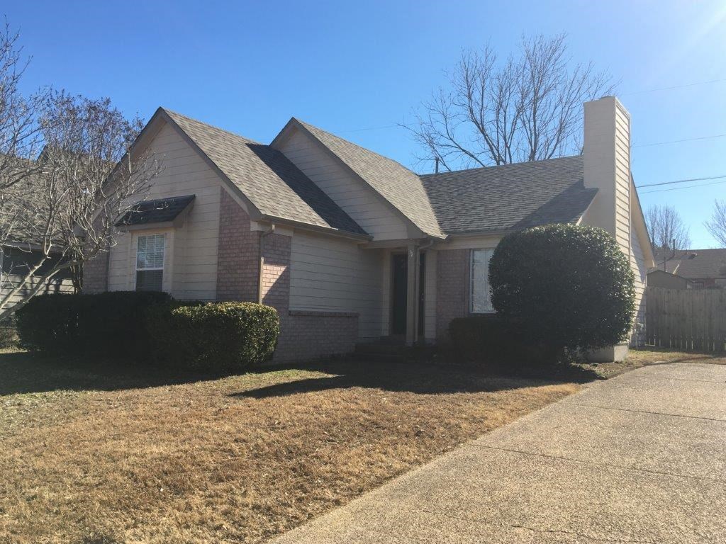 a small house with a sidewalk in front of it
