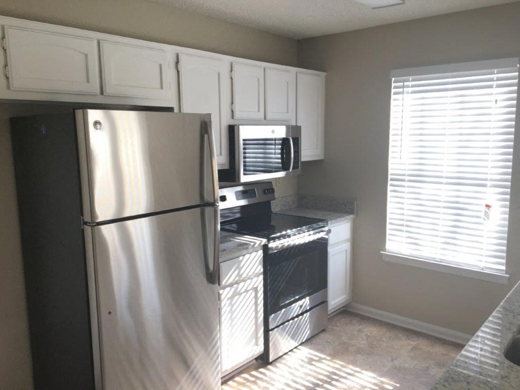 a kitchen with a refrigerator and a microwave