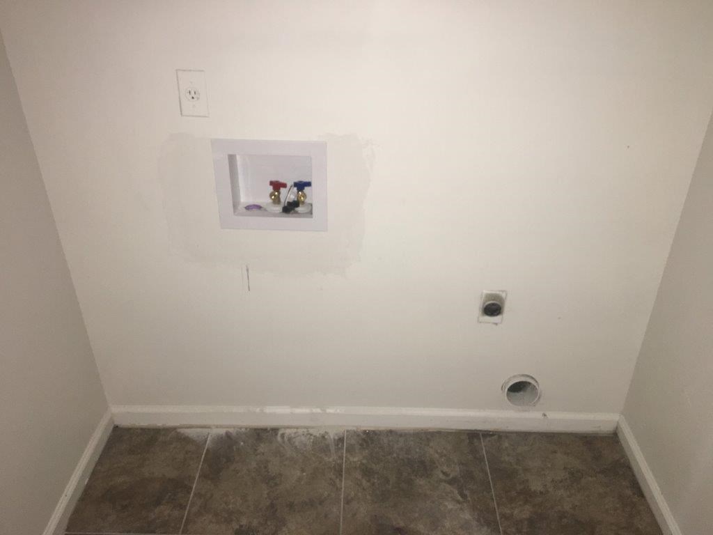 a wall with a hole in the wall and a outlet on the wall