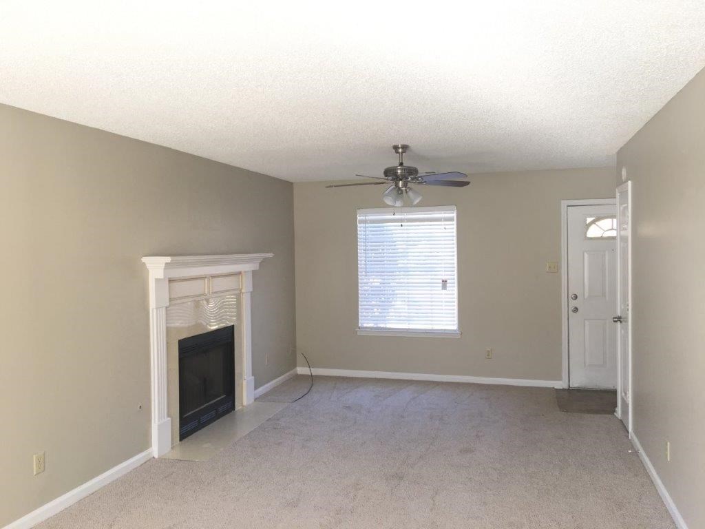 a living room with a fireplace and a ceiling fan
