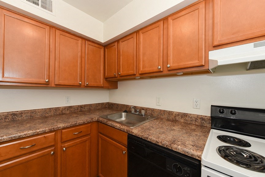 a kitchen with wooden cabinets and a stove and sink