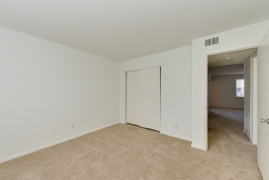 an empty living room with a door to a bedroom