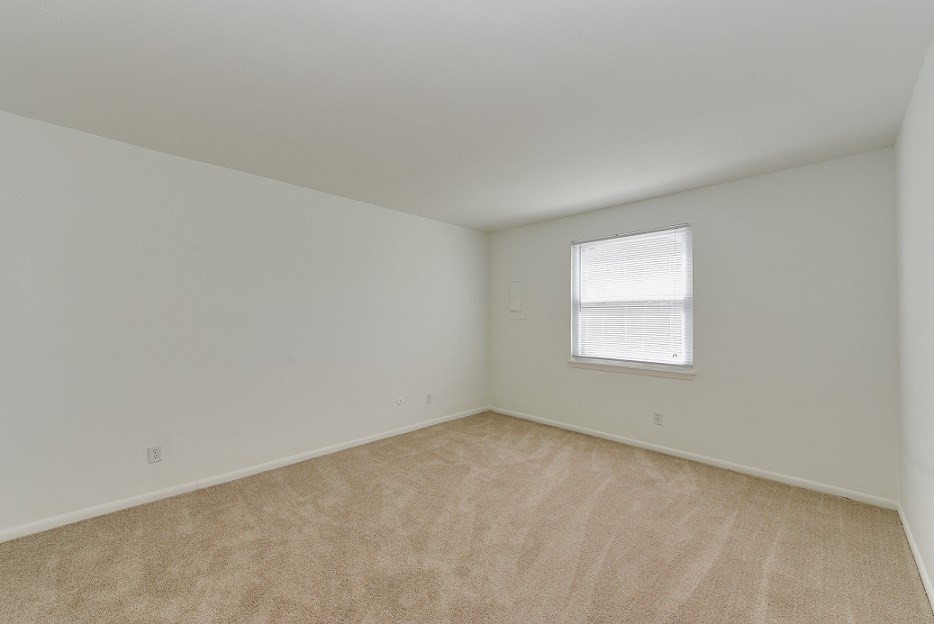an empty room with carpet and a window