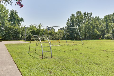 A playground with a swing set and a walkway.