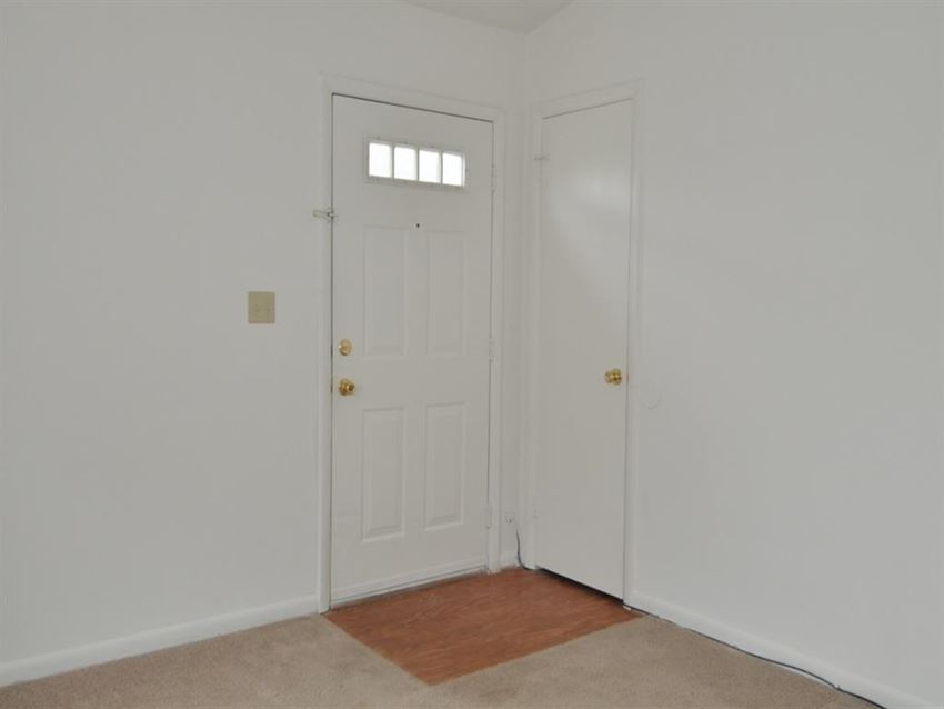 a room with a white door and a door to a closet