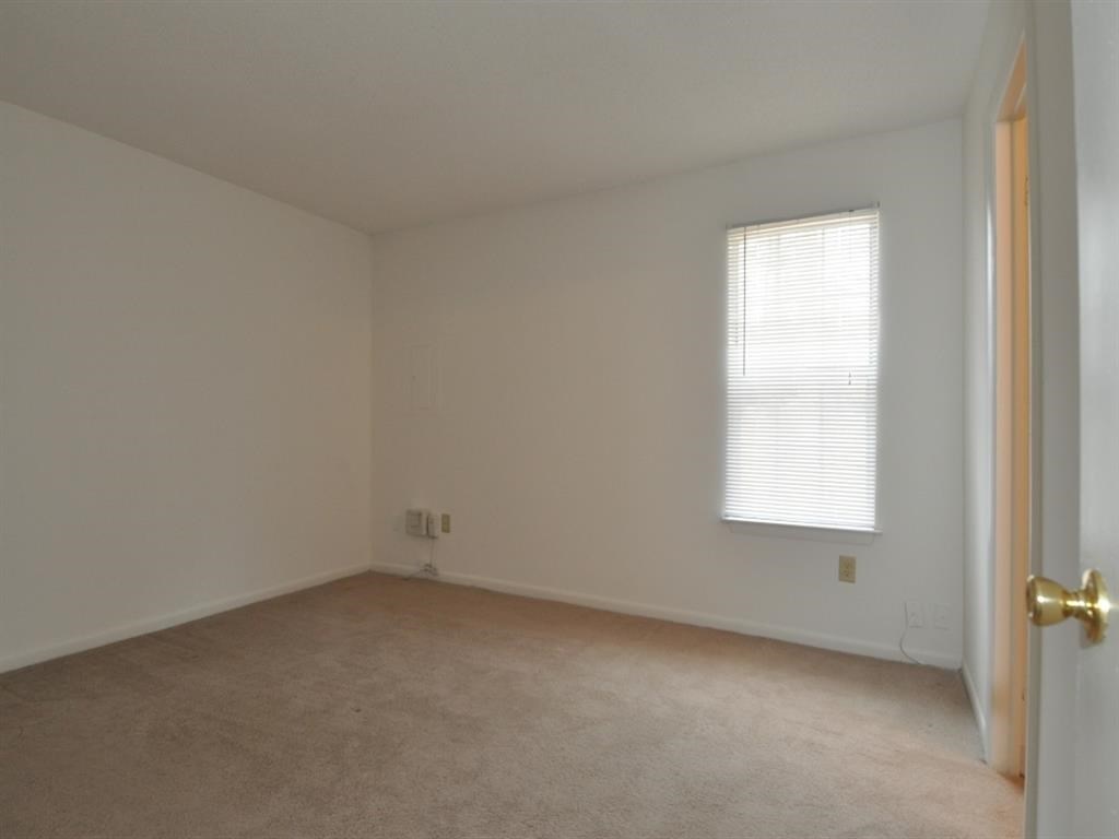 an empty room with a window and a door