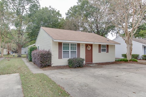 a small white house with a porch and a driveway