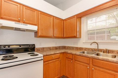 a kitchen with a stove and sink and a window