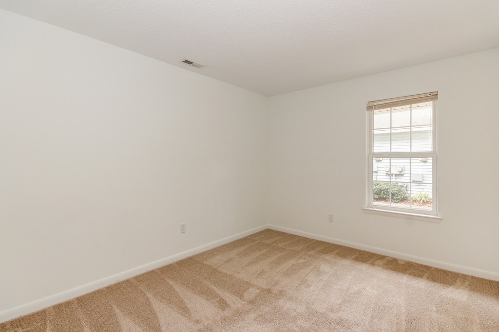 an empty room with white walls and a window