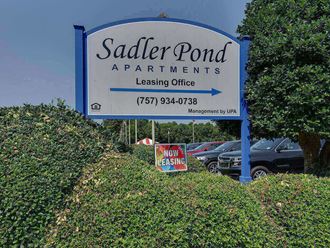 a sign for saunders pond apartments in front of a parking lot