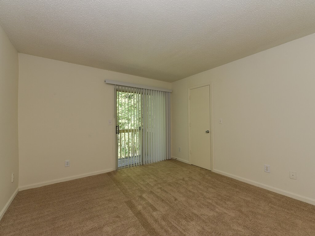 an empty living room with a door to a patio