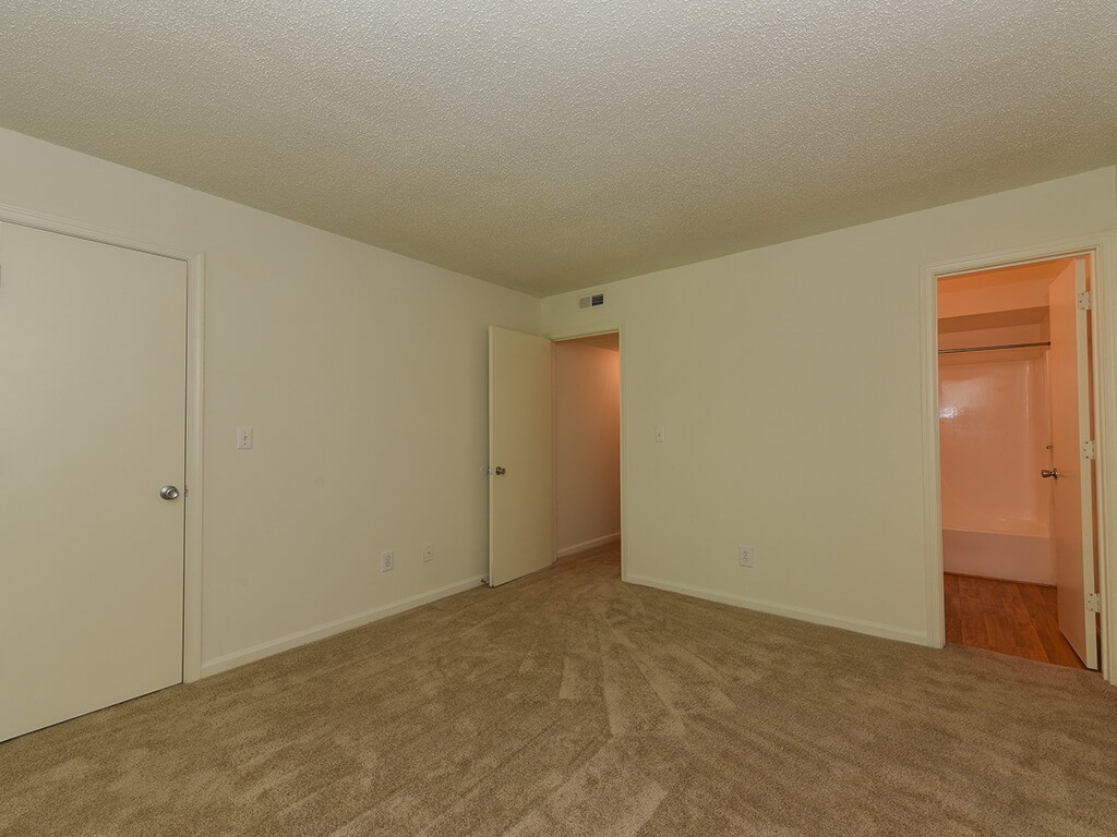 an empty living room with a door to a closet