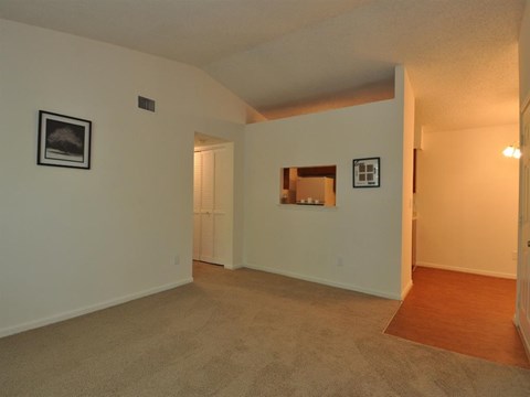 a living room with white walls and a door to a bathroom