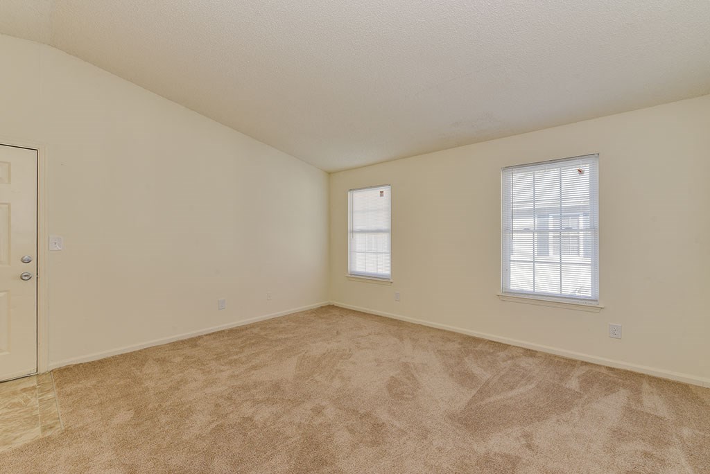 an empty living room with a door and window