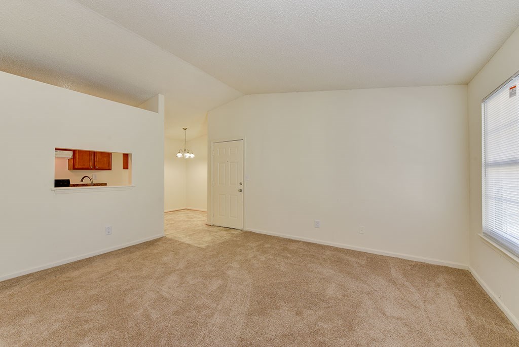 the spacious living room and dining room of an apartment