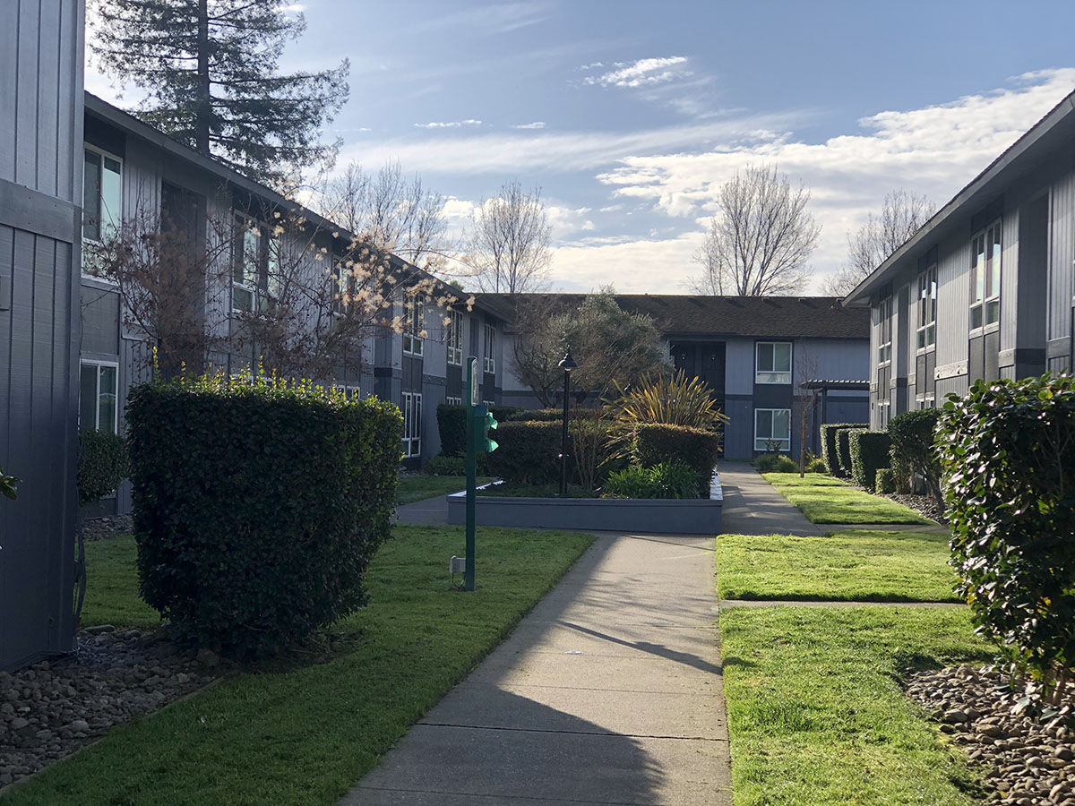Sidewalk through apartment buildings with landscape