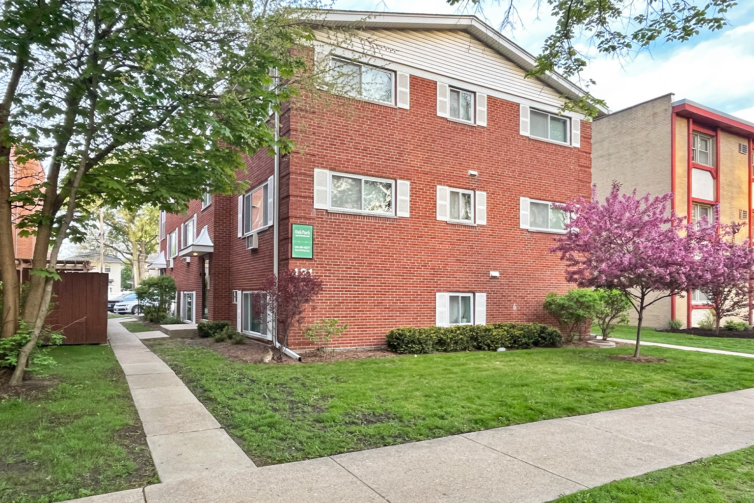 A red brick building with a green sign on it.