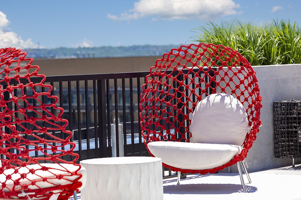a seating area with chairs and a table on a balcony