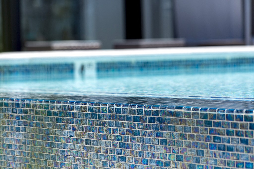 a swimming pool with mosaic tiles on the side of it