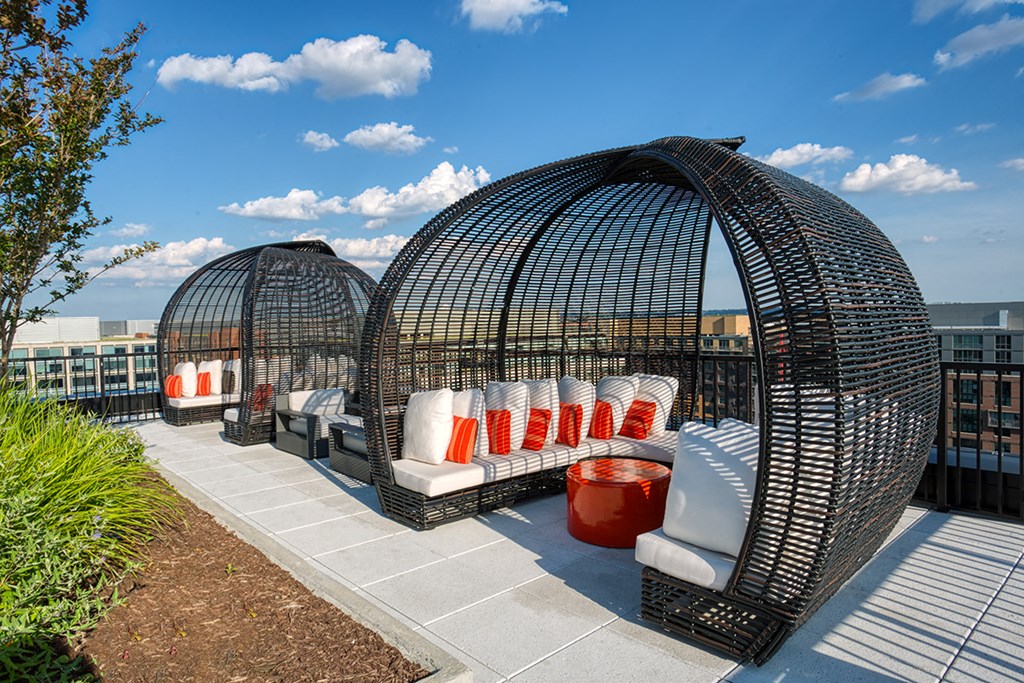 a rooftop lounge area with furniture and a view of the city