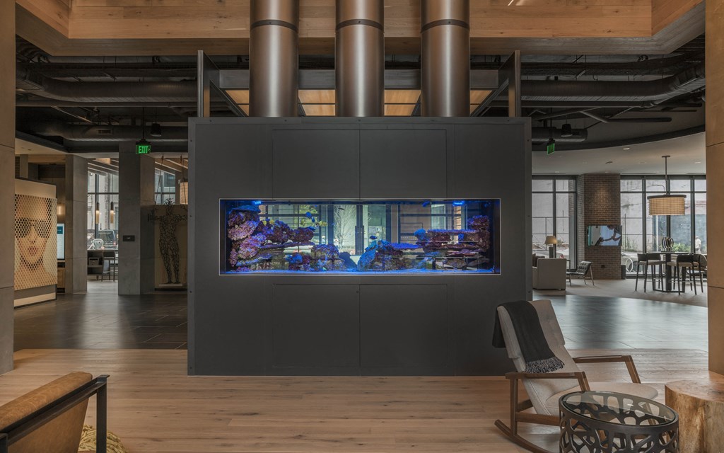 a large aquarium in a room with chairs and a table