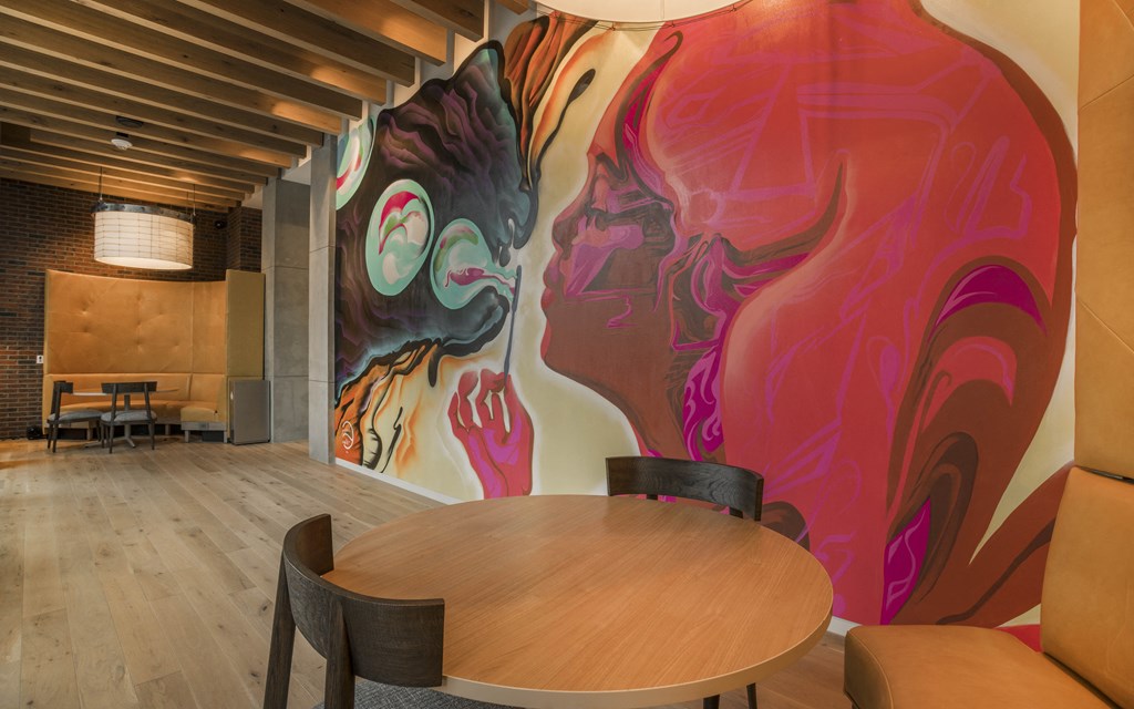 a dining room with a wall mural of a woman and a man