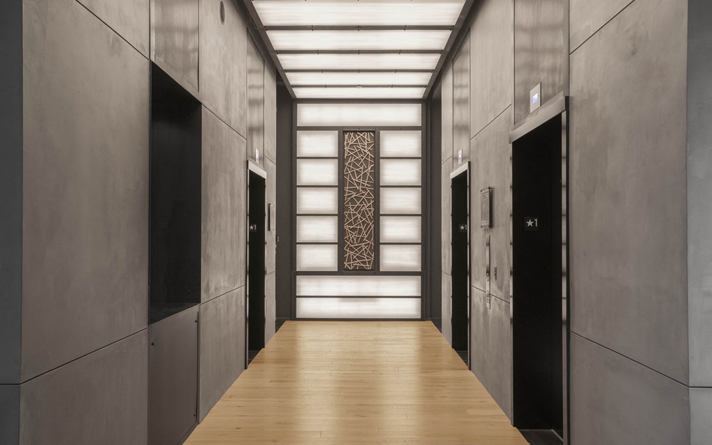 a hallway with black doors and wood floors and a mural on the wall