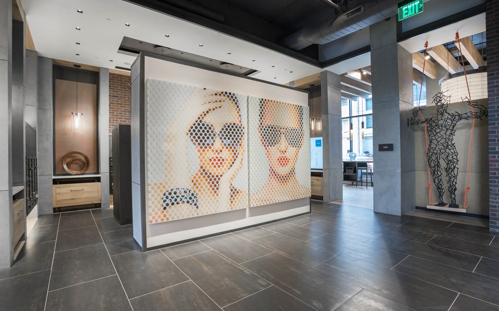 a display case in a lobby of a building with three portraits of people on it