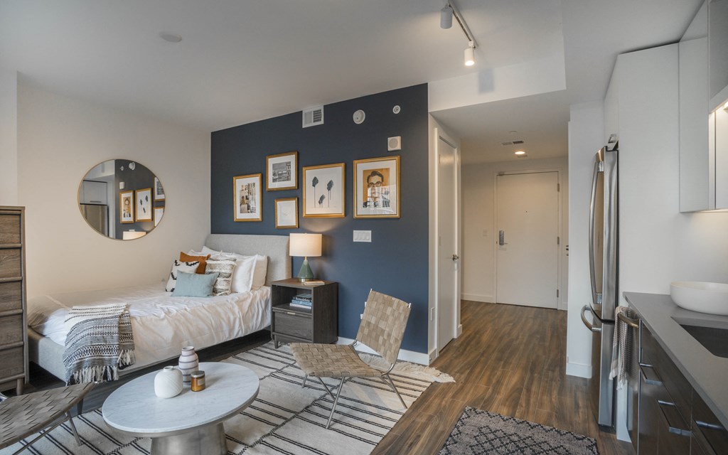 a bedroom with a bed and a blue accent wall and a bathroom