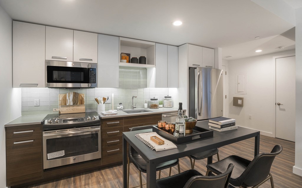 a kitchen with stainless steel appliances and a table with chairs