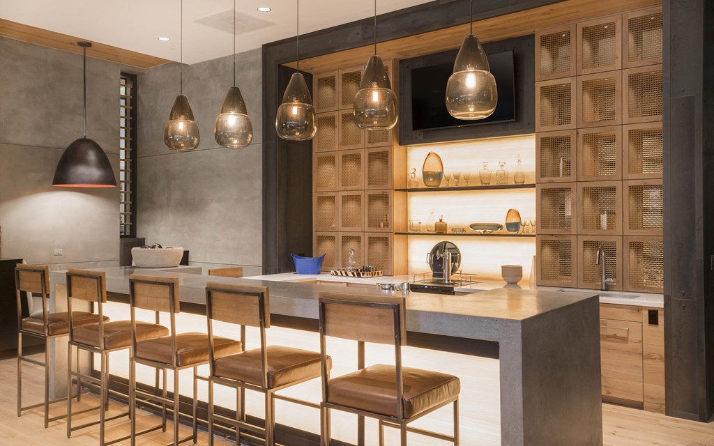 a kitchen with a marble counter top and wooden chairs
